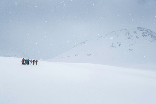 Ski tourers march upwards towards the summit of this Norwegian peak in heavy snow in this photograph
