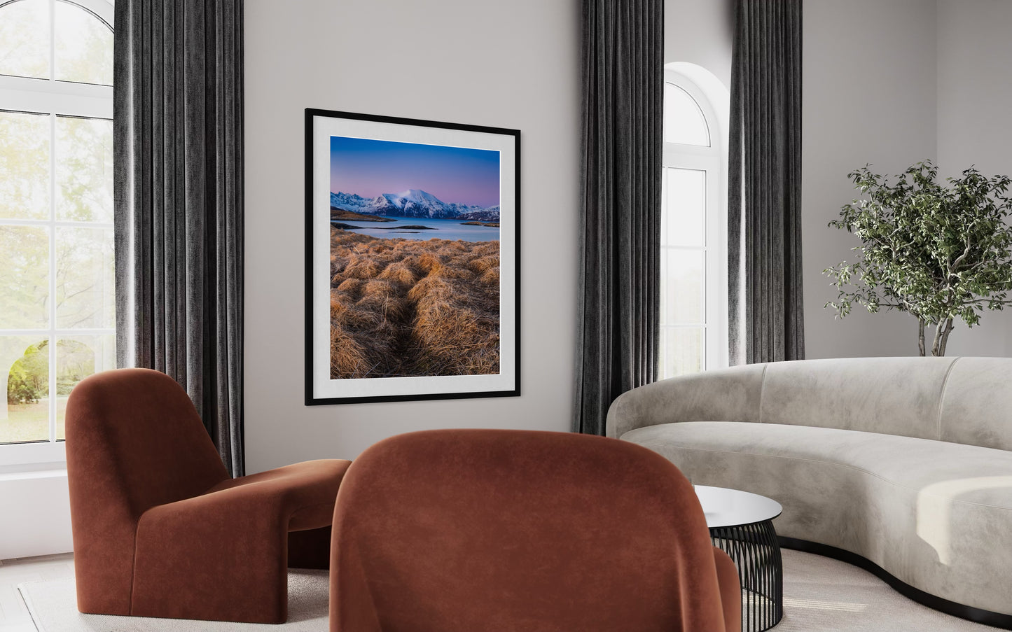 Modern living room with brown chairs, beige sofa, and framed artwork of snowy Norwegian mountain scene and fjord on the wall.