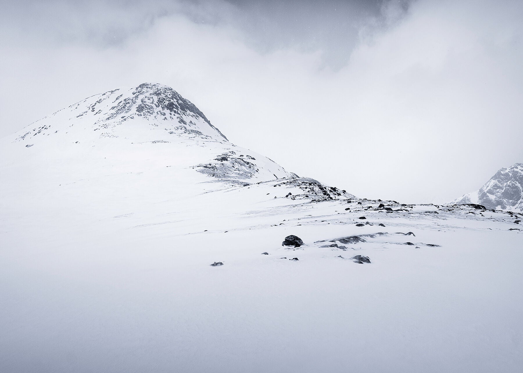 Arnoya, Norway, where the late winter sun is always low in the sky creating beautiful soft conditions for photography. This fine art photo displays the route to the summit with muted colours adding balance to the naturally uncluttered scene  littered by rocks
