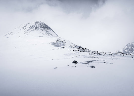Arnoya, Norway, where the late winter sun is always low in the sky creating beautiful soft conditions for photography. This fine art photo displays the route to the summit with muted colours adding balance to the naturally uncluttered scene  littered by rocks