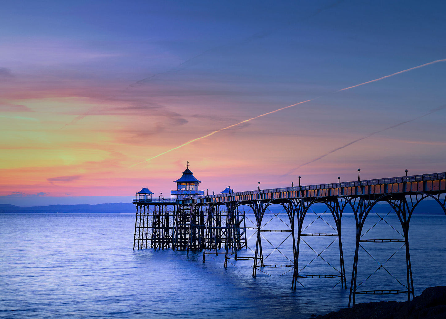 Colour photo showing a balmy summers evening sunset at Clevedon pier looking out to see