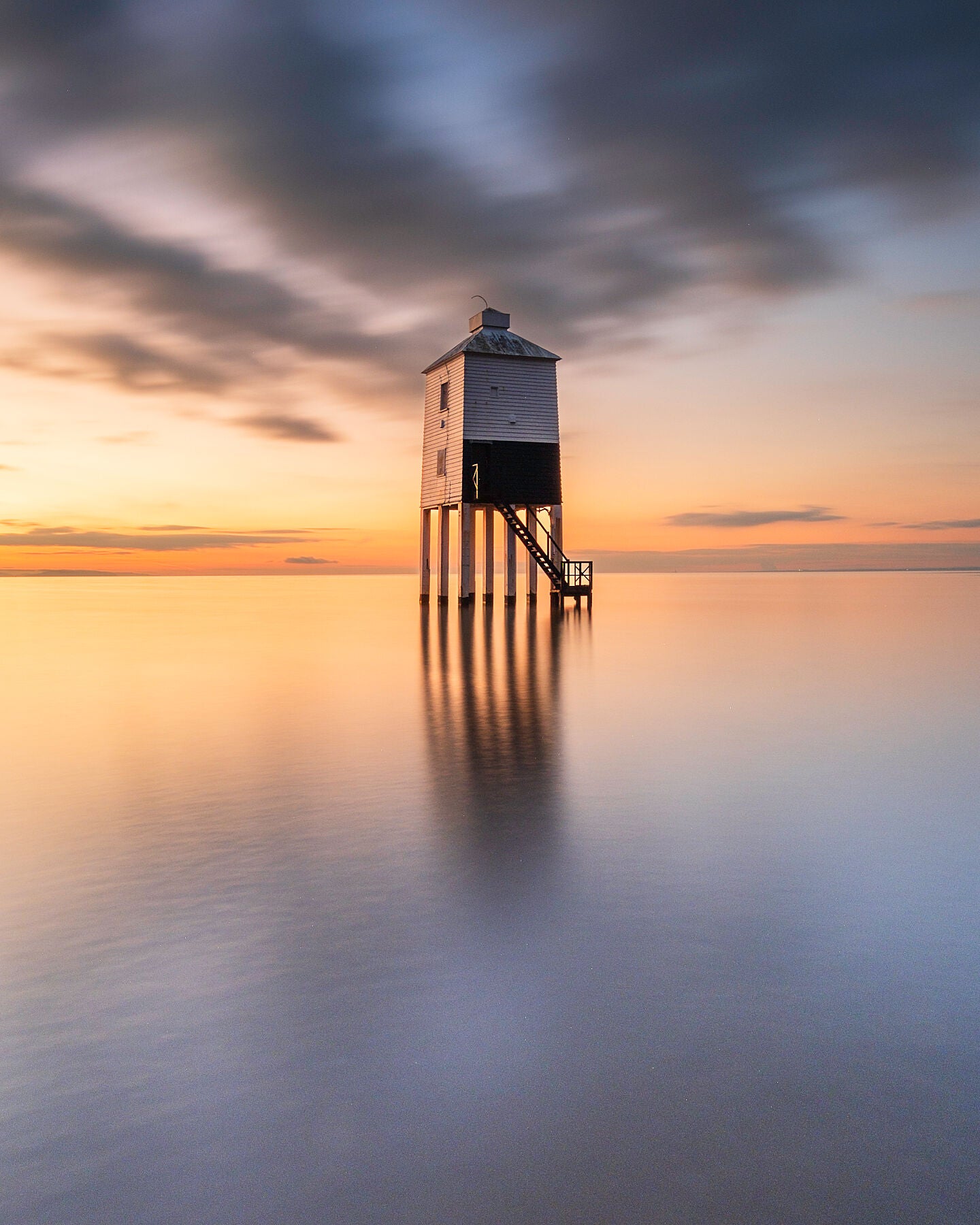 Burnham low lighthouse in the Severn estuary at sunset as the incoming tide sweeps over the sands
