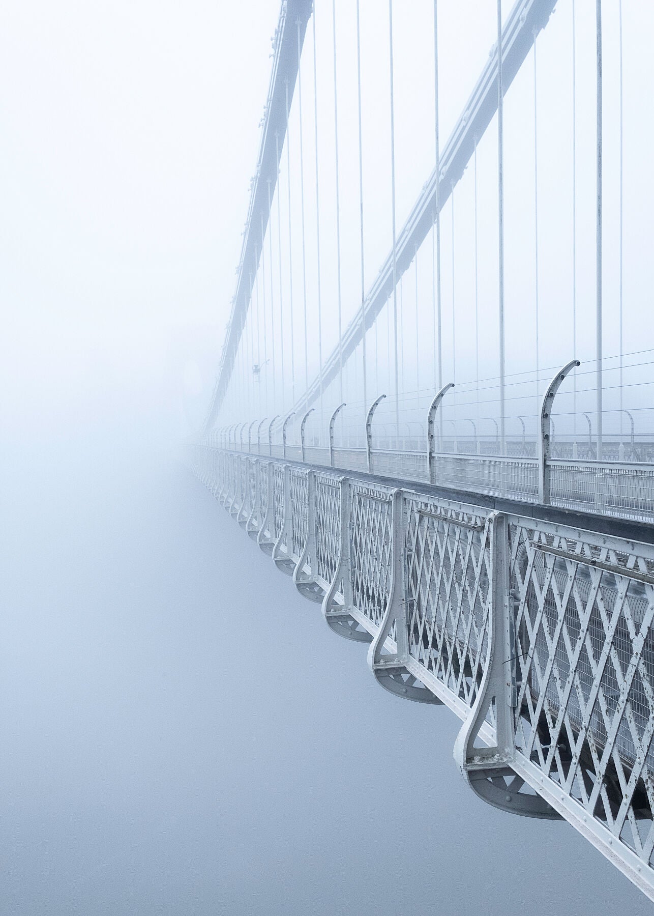 Beautiful colour  high resolution photo of Clifton Suspension Bridge receding into thick fog toward the light breaking through in the distance