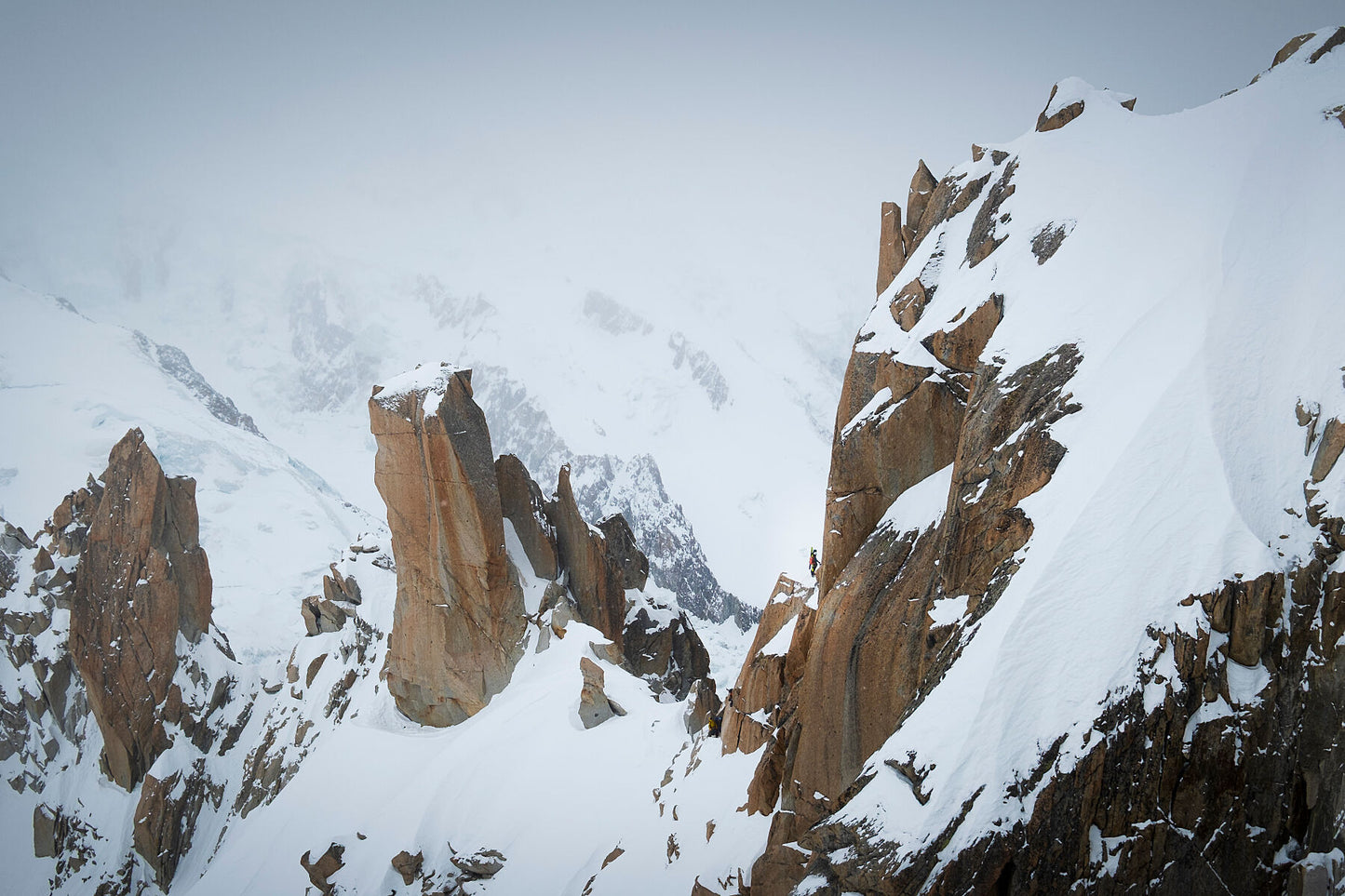 Climbers laden with touring skis start to ascend the Arête des Cosmiques in the Mont Blanc Massif above Chamonix