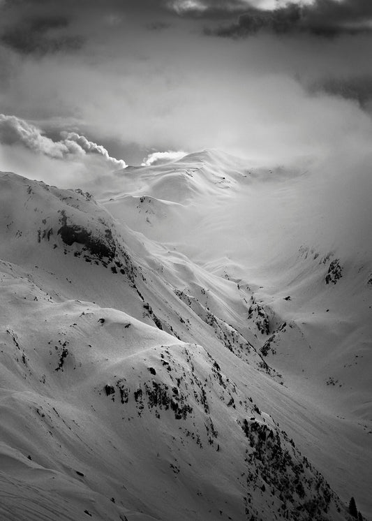 Les rochers des enclave above les Contamines reveals itself through the clouds while fresh snow covers the landscape