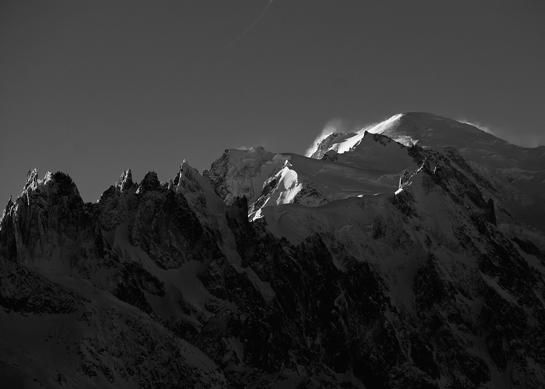 Wind blowing snow from the summit of Mont blanc and surrounding alpine mountains of the Mont Blanc Massif