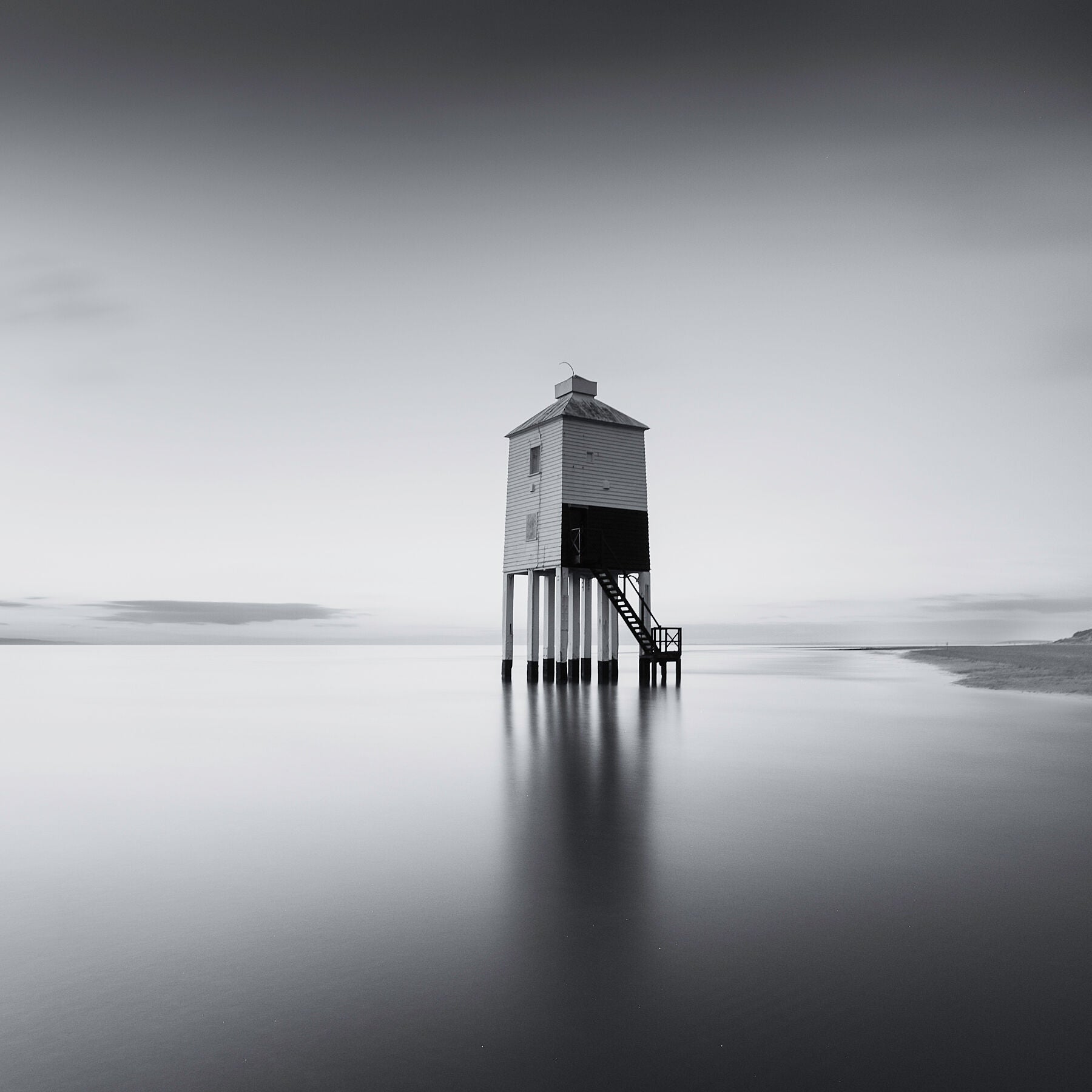 High tide sweeps past the Burham low lighthouse in the severn estuary, which stands isolated and proud in this beautiful black and white photograph