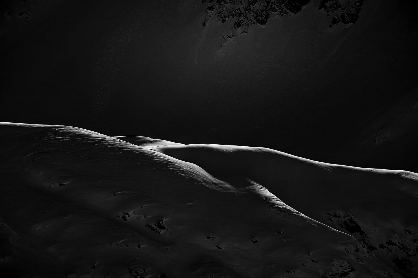 Fine art photo showing Sunlight lighting  the ridges of the Chamonix mountainside, drawing lines almost looking like a pencil drawing.