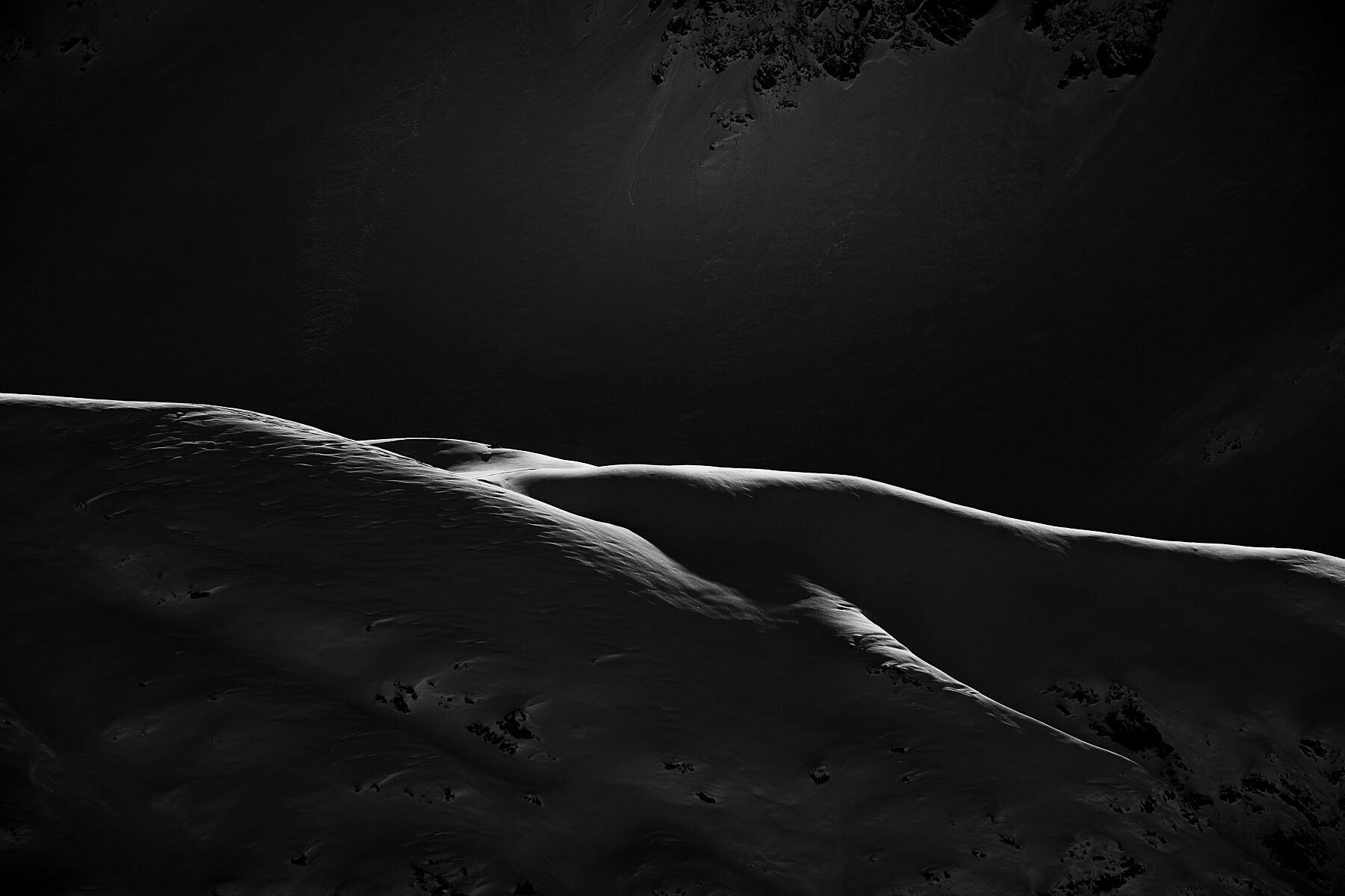 Fine art photo showing Sunlight lighting  the ridges of the Chamonix mountainside, drawing lines almost looking like a pencil drawing.