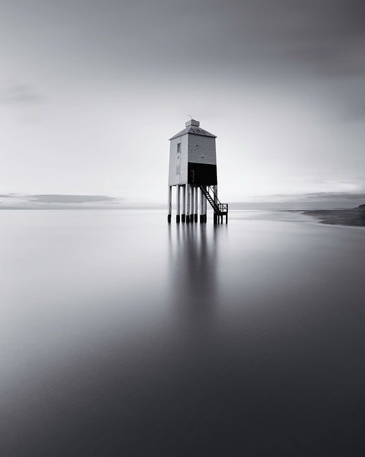 High tide sweeps across the sands surrounding the Burham Low lighthouse in the severn estuary, which stands isolated and proud in this beautiful black and white photograph