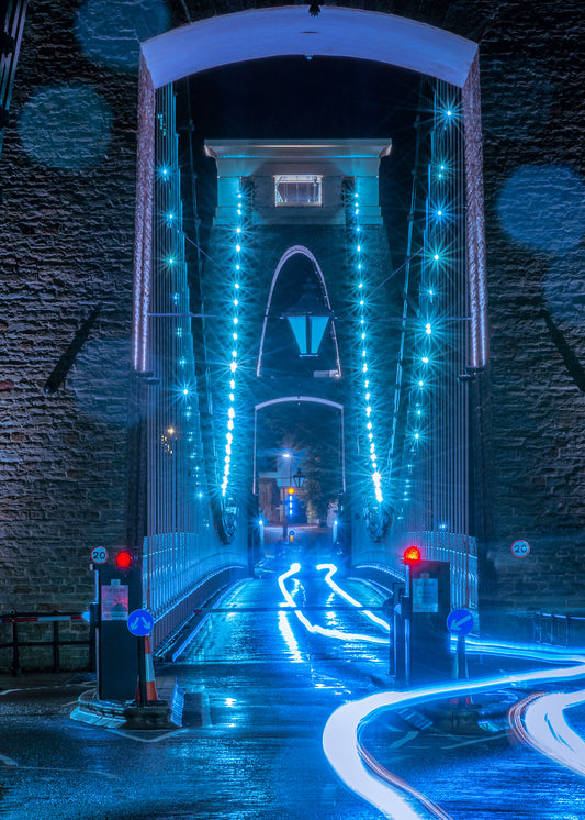 Clifton suspension bridge at night in unusual neon blue lighting with glistening raindrops on the camera lens
