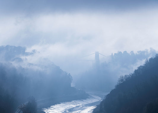 Clifton Suspension Bridge in the distance breaking free of the morning fog, with the River Avon below and the Avon gorge