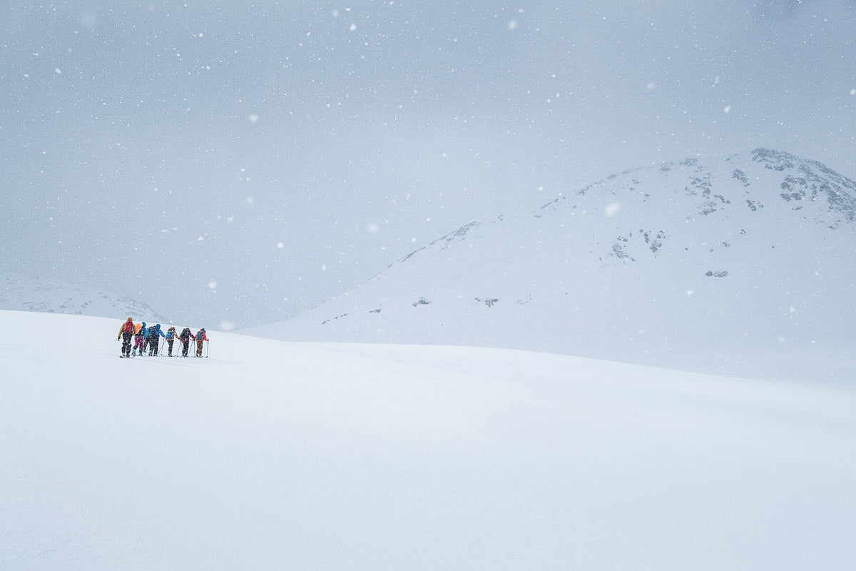 Ski tourers march upwards towards the summit of this Norwegian peak in heavy snow in this photograph