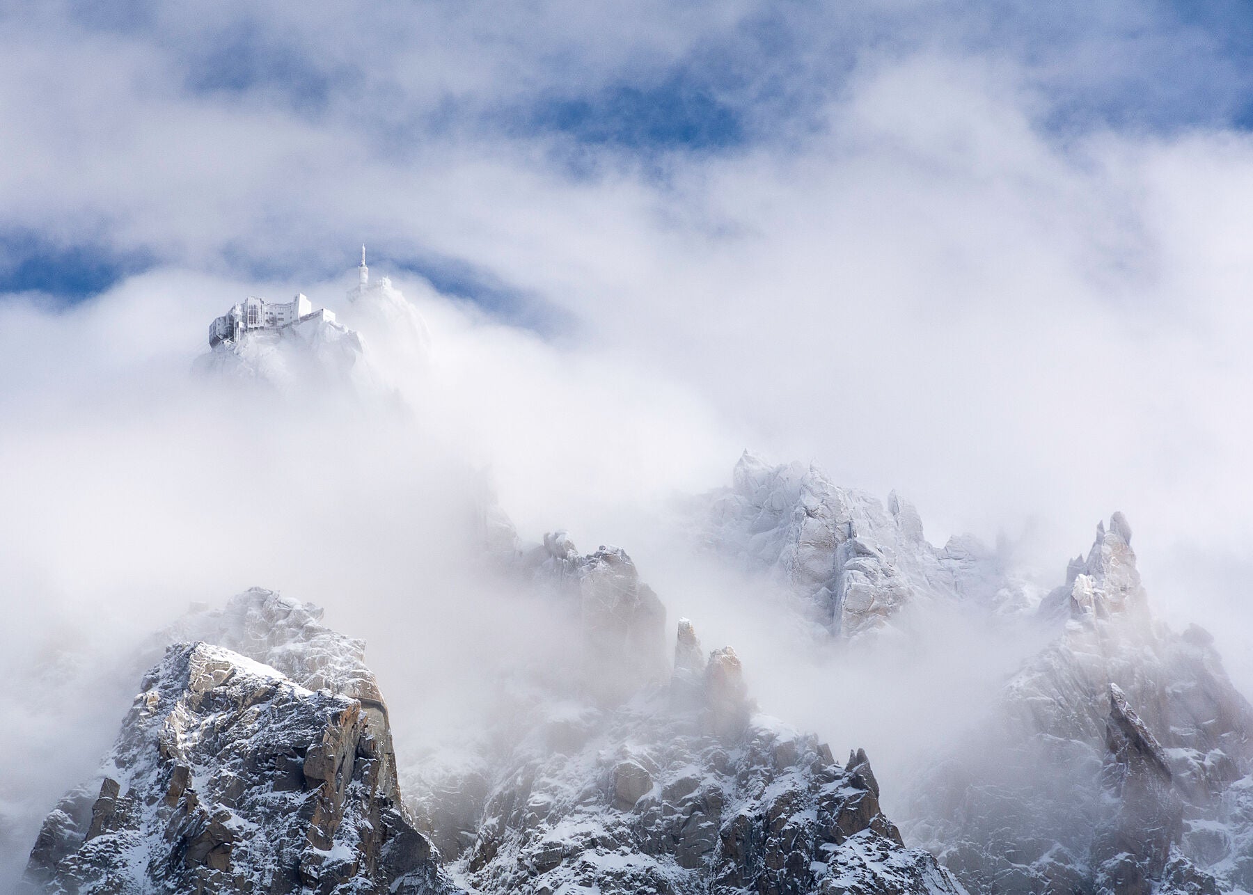 Dramtic photo of the Aiguille du Midi station in cloud high above Chamonix Mont Blanc