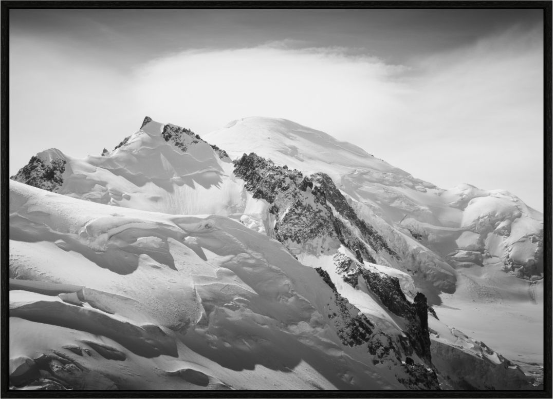 The summit of Mont Blanc capped with lenticular cloud, with glaciers in the foreground
