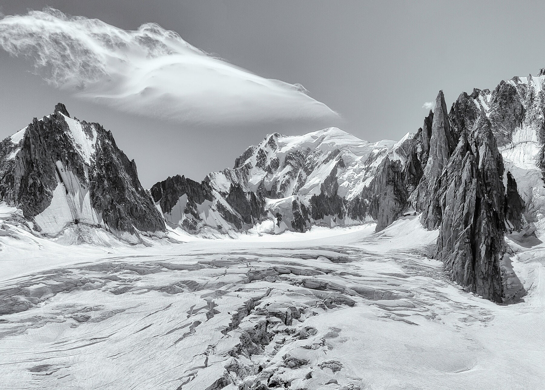 The view over a glacier towards the summit of Mont Blanc above Chamonix in the French Alps, with dramatic peaks and a beautiful cloud
